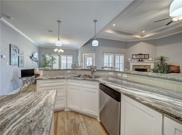 kitchen featuring sink, hanging light fixtures, light wood-type flooring, dishwasher, and white cabinets