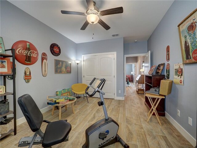 workout area featuring ceiling fan and light wood-type flooring