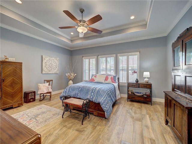 bedroom with crown molding, ceiling fan, a tray ceiling, and light hardwood / wood-style flooring