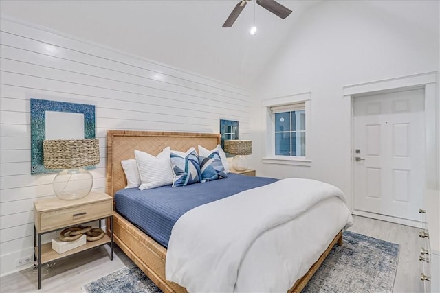 bedroom with a ceiling fan, high vaulted ceiling, and wood finished floors