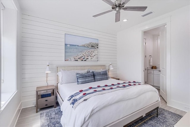 bedroom featuring wooden walls, recessed lighting, visible vents, and light wood-style flooring