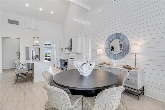 dining area with high vaulted ceiling, light wood-style flooring, recessed lighting, visible vents, and baseboards