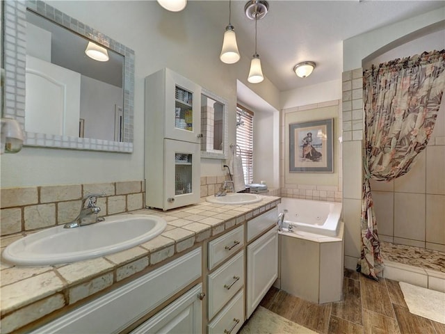 bathroom featuring wood-type flooring, vanity, and shower with separate bathtub