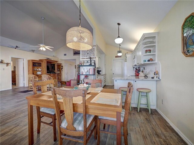 dining space featuring ceiling fan, dark hardwood / wood-style floors, and vaulted ceiling