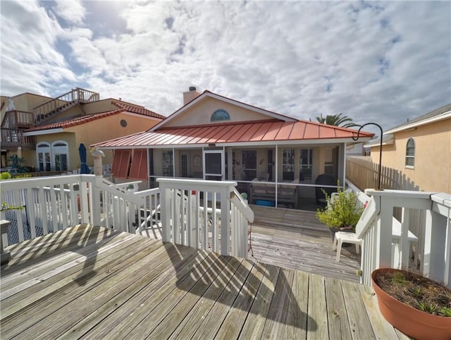 wooden deck with a sunroom