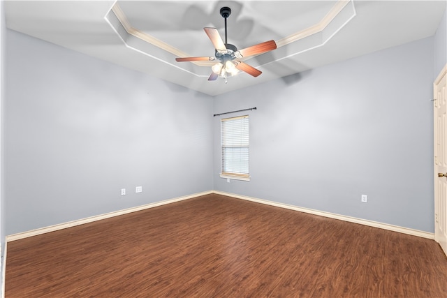 empty room featuring hardwood / wood-style flooring, ceiling fan, and a raised ceiling