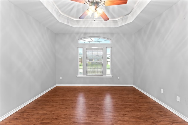 unfurnished room with wood-type flooring, a raised ceiling, ceiling fan, and crown molding