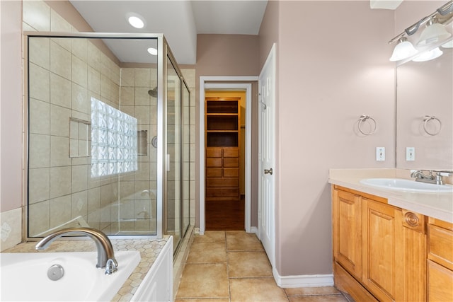 bathroom featuring independent shower and bath, vanity, and tile patterned flooring