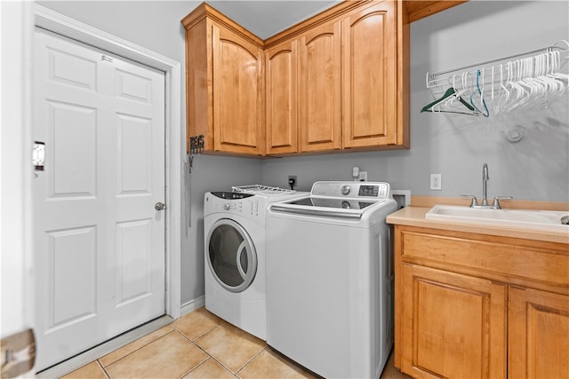 laundry area featuring cabinets, separate washer and dryer, sink, and light tile patterned floors