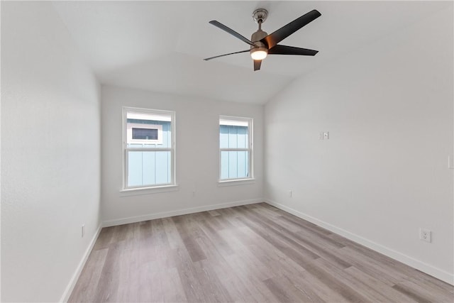 empty room with vaulted ceiling, ceiling fan, and light hardwood / wood-style flooring