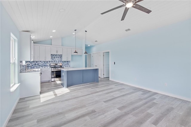 kitchen featuring pendant lighting, stainless steel electric range, backsplash, a kitchen island, and vaulted ceiling