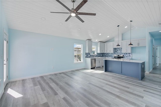 kitchen with a kitchen island, appliances with stainless steel finishes, gray cabinetry, decorative backsplash, and hanging light fixtures