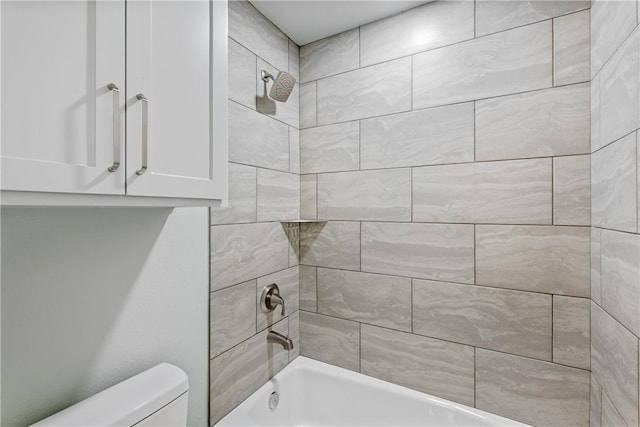 bathroom featuring tiled shower / bath and toilet