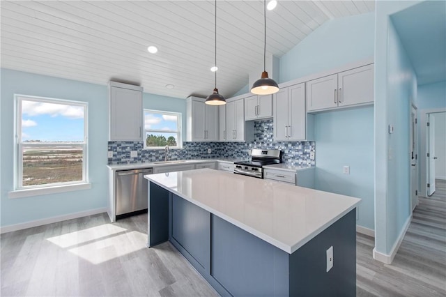 kitchen featuring sink, decorative light fixtures, a center island, appliances with stainless steel finishes, and decorative backsplash