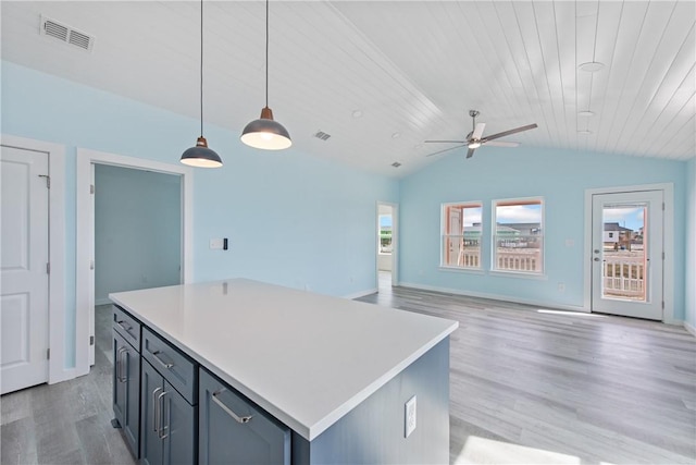 kitchen featuring pendant lighting, a center island, vaulted ceiling, and light hardwood / wood-style flooring