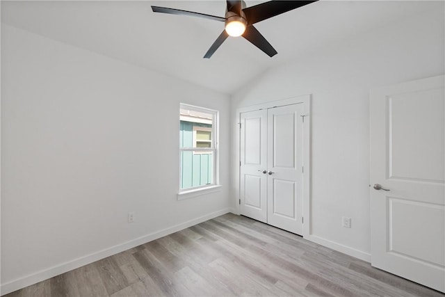 unfurnished bedroom featuring vaulted ceiling, a closet, ceiling fan, and light hardwood / wood-style flooring