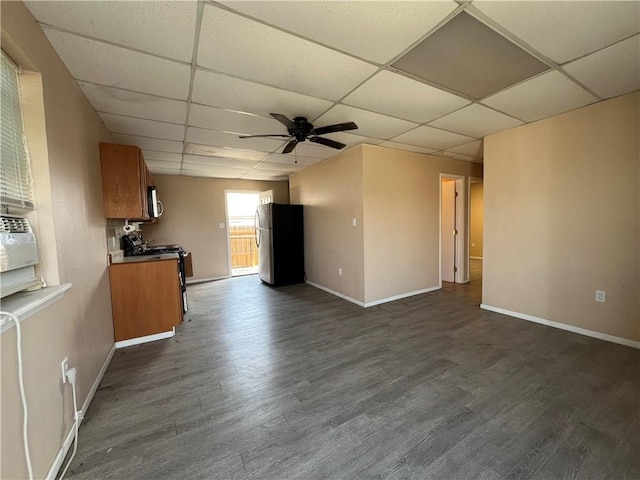 interior space featuring ceiling fan, a paneled ceiling, and dark hardwood / wood-style floors