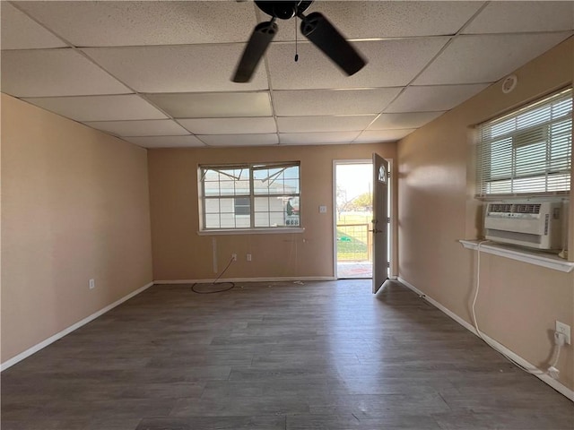 empty room featuring dark wood-type flooring, a paneled ceiling, and cooling unit