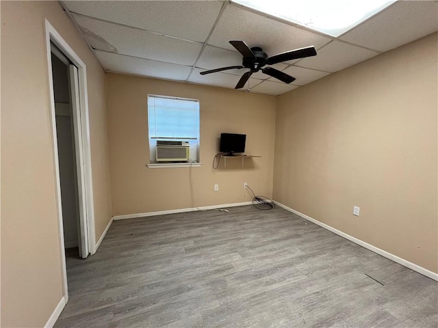 unfurnished room with cooling unit, ceiling fan, a drop ceiling, and hardwood / wood-style floors