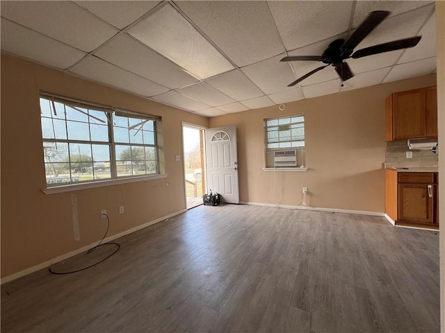 unfurnished living room featuring a paneled ceiling, cooling unit, and wood-type flooring