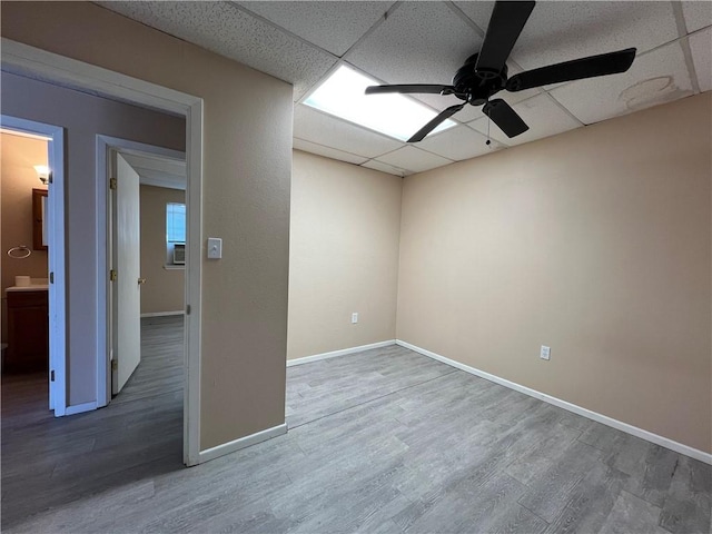 unfurnished room featuring a paneled ceiling, ceiling fan, and wood-type flooring