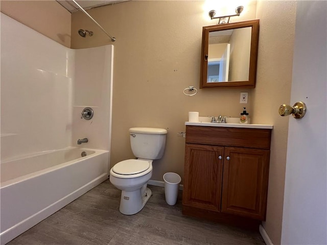 full bathroom with hardwood / wood-style floors, toilet,  shower combination, and vanity