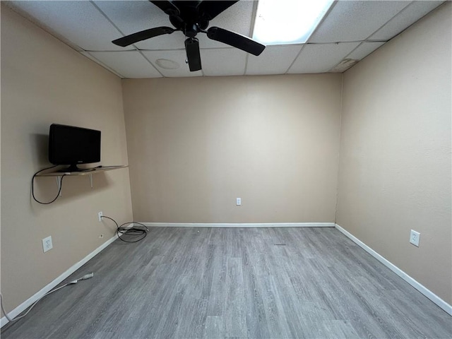 interior space with ceiling fan, a drop ceiling, and wood-type flooring