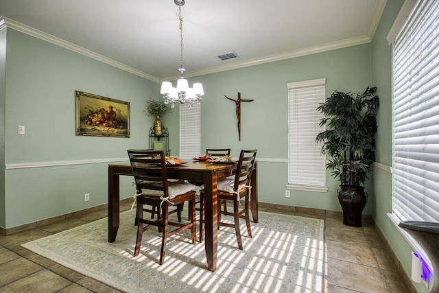 dining space with baseboards, a notable chandelier, visible vents, and crown molding