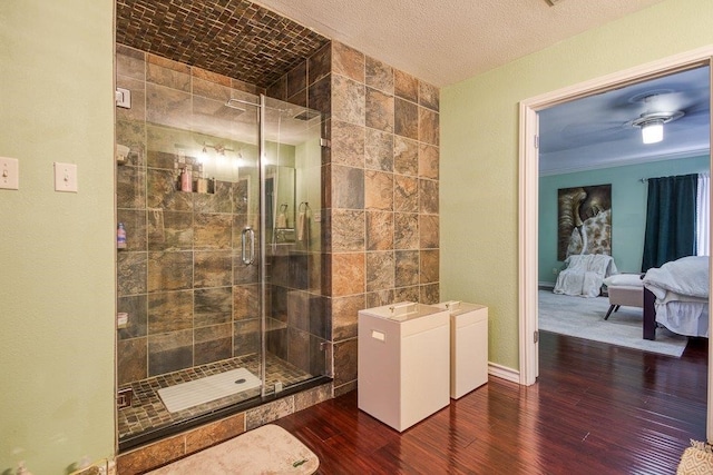 ensuite bathroom with baseboards, a shower stall, ensuite bathroom, and wood finished floors