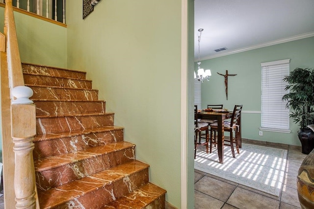 stairs with visible vents, baseboards, tile patterned floors, an inviting chandelier, and crown molding