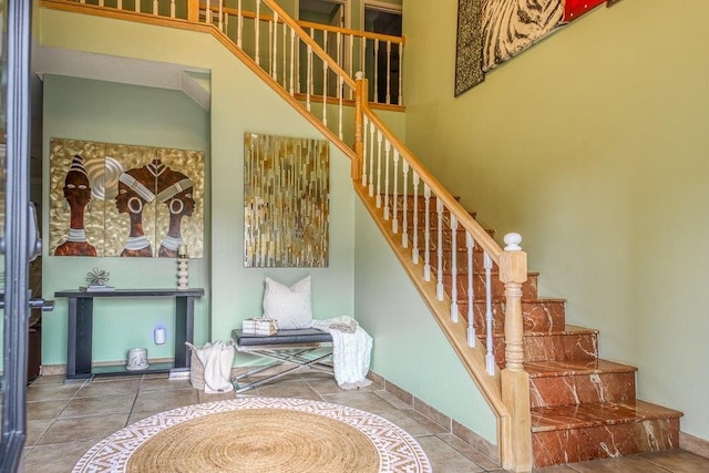 staircase featuring tile patterned flooring and baseboards