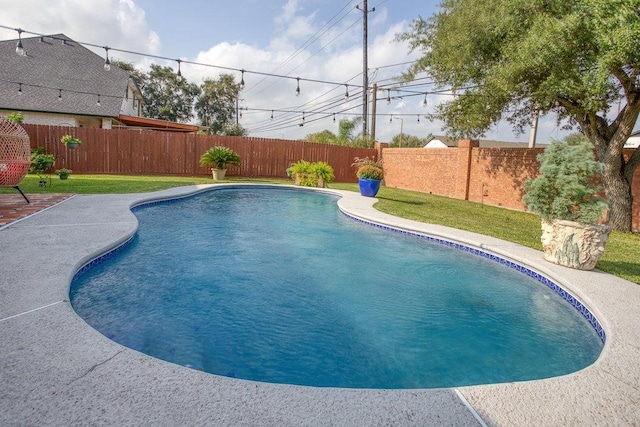 view of swimming pool featuring a fenced backyard, a lawn, a fenced in pool, and a patio