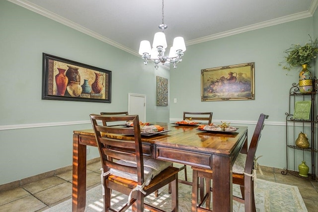 dining space with baseboards, ornamental molding, and a notable chandelier