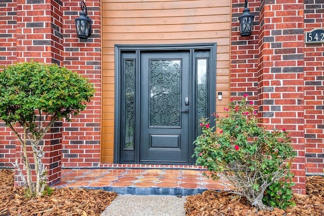 view of exterior entry with brick siding