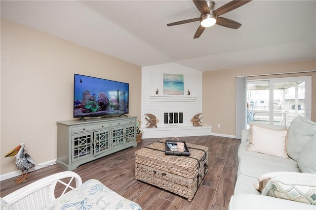 living room with a fireplace, vaulted ceiling, and ceiling fan