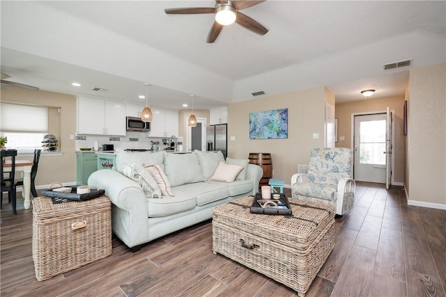 living room featuring ceiling fan and dark wood-type flooring