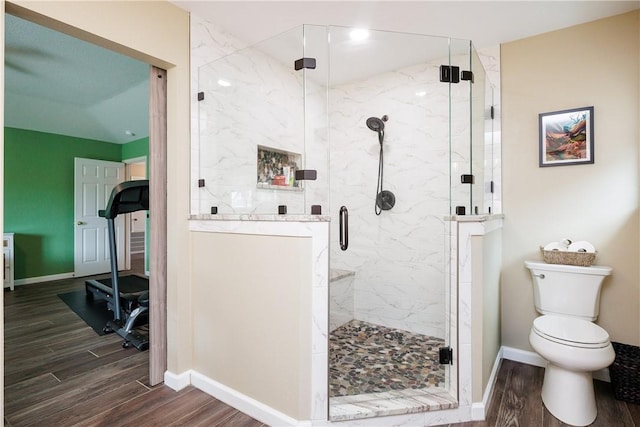 bathroom featuring hardwood / wood-style floors, toilet, and an enclosed shower