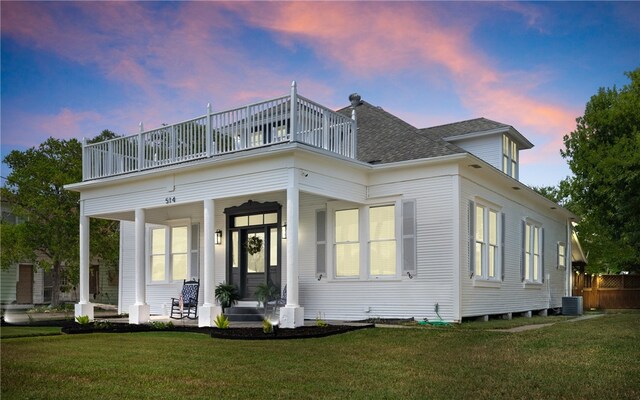 514 W 4th St, Sinton, TX 78387 - view of front of house with a balcony, a porch, and a lawn