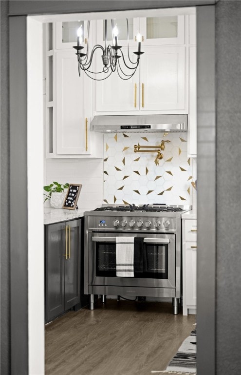 bar featuring dark hardwood / wood-style flooring, tasteful backsplash, range with two ovens, a notable chandelier, and white cabinets