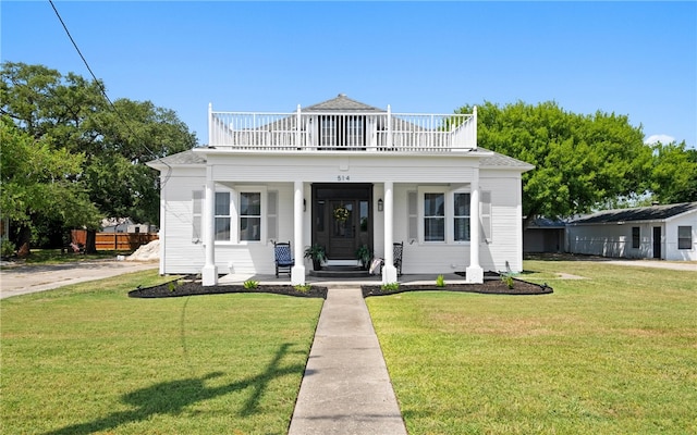 view of front of property with a balcony and a front yard