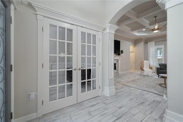 interior space featuring arched walkways, ceiling fan, wood finished floors, coffered ceiling, and beamed ceiling