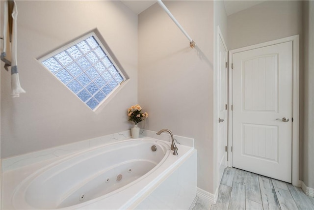 full bath with a tub with jets and wood finished floors