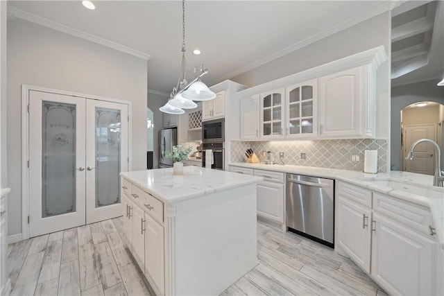 kitchen with stainless steel appliances, arched walkways, wood finish floors, and a sink