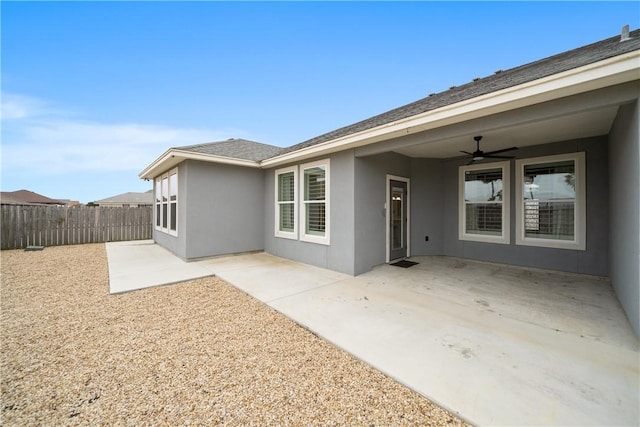 rear view of property with stucco siding, a patio area, ceiling fan, and fence