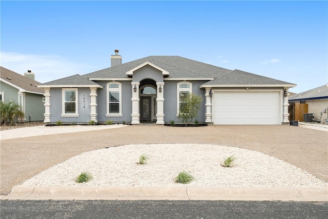 view of front of house featuring a garage, concrete driveway, a shingled roof, and stucco siding