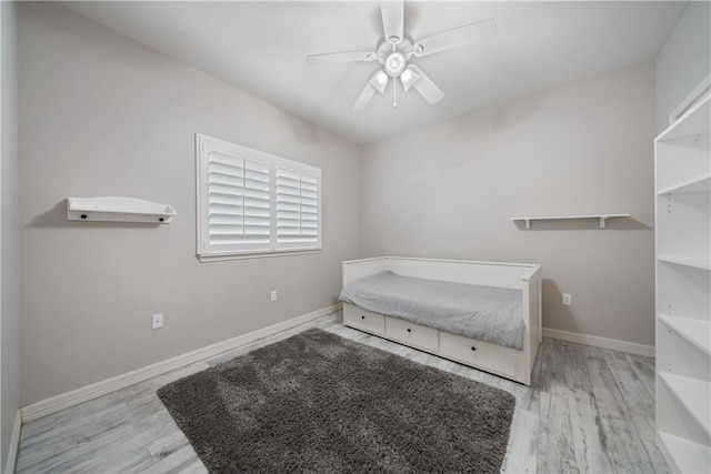 bedroom with ceiling fan, wood finished floors, and baseboards