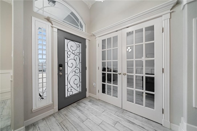 foyer entrance with french doors, baseboards, and wood finished floors