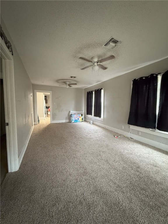 unfurnished living room featuring carpet flooring, a textured ceiling, and ceiling fan