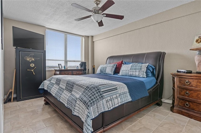 bedroom with a ceiling fan and a textured ceiling