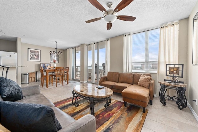 living area featuring a textured ceiling, light tile patterned floors, ceiling fan with notable chandelier, and baseboards